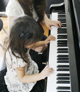 ミューズアート音楽学院の子供の生徒さんにピアノのレッスンをしている様子の写真